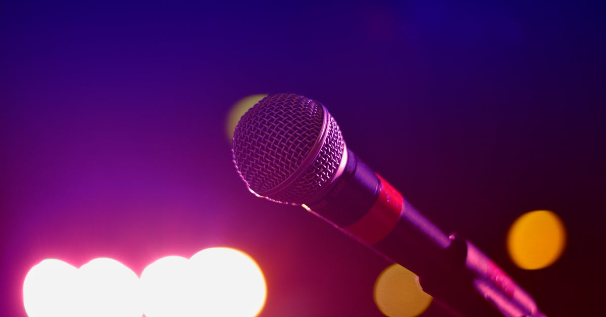 Colorful stage lighting highlights a microphone in a close-up view, perfect for music and performance themes.