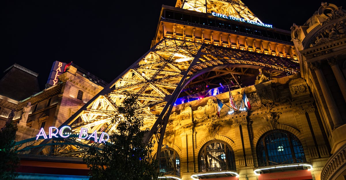 Night view of the Eiffel Tower replica at Paris Las Vegas, showcasing vibrant lights and architecture.