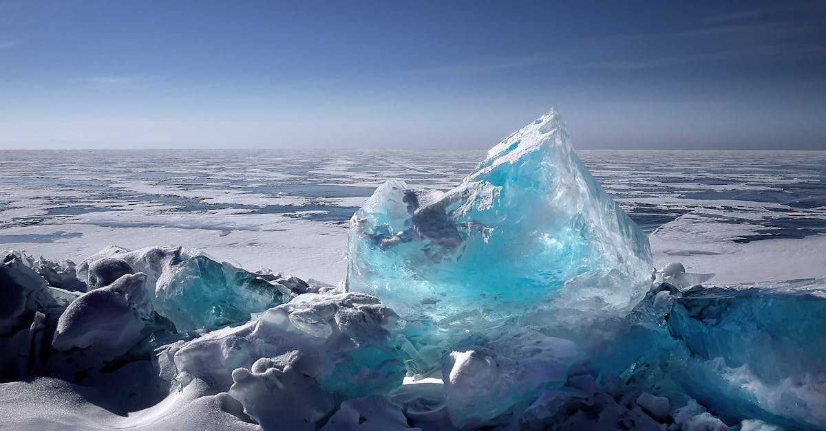 Captivating ice formation on a frozen lake under a bright blue sky during winter.