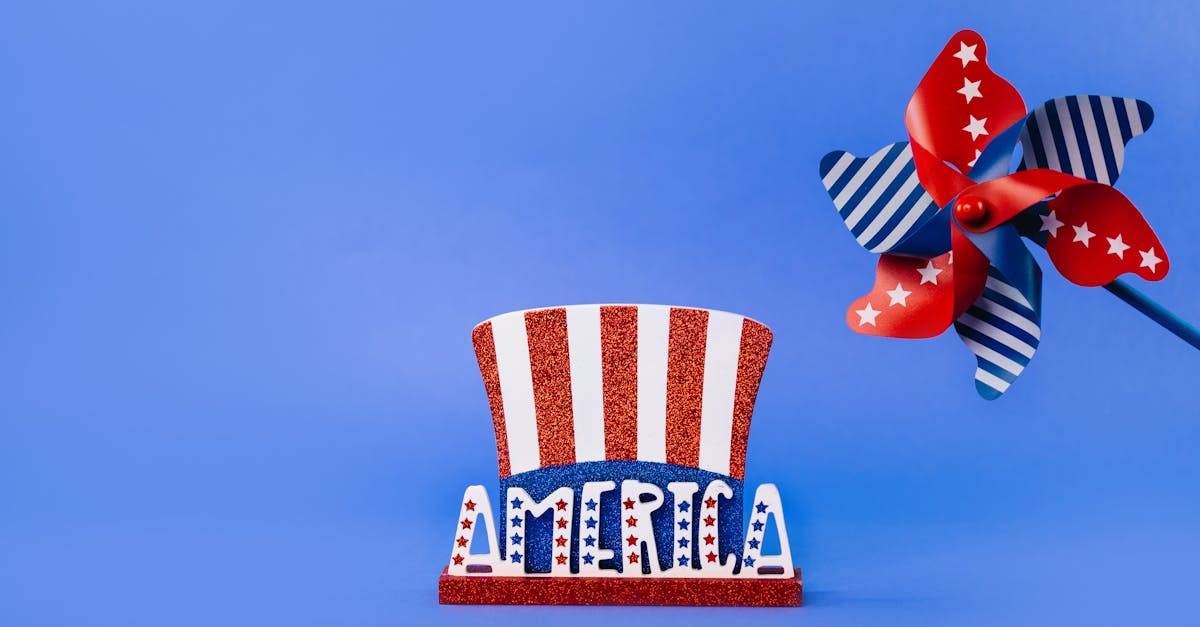 A vibrant blue background with a patriotic decoration featuring a glittery Uncle Sam hat and a red, white, and blue pinwheel.