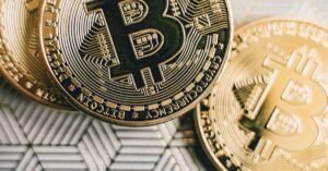 Close-up of Bitcoin coins placed on a geometric patterned surface, representing cryptocurrency and finance.